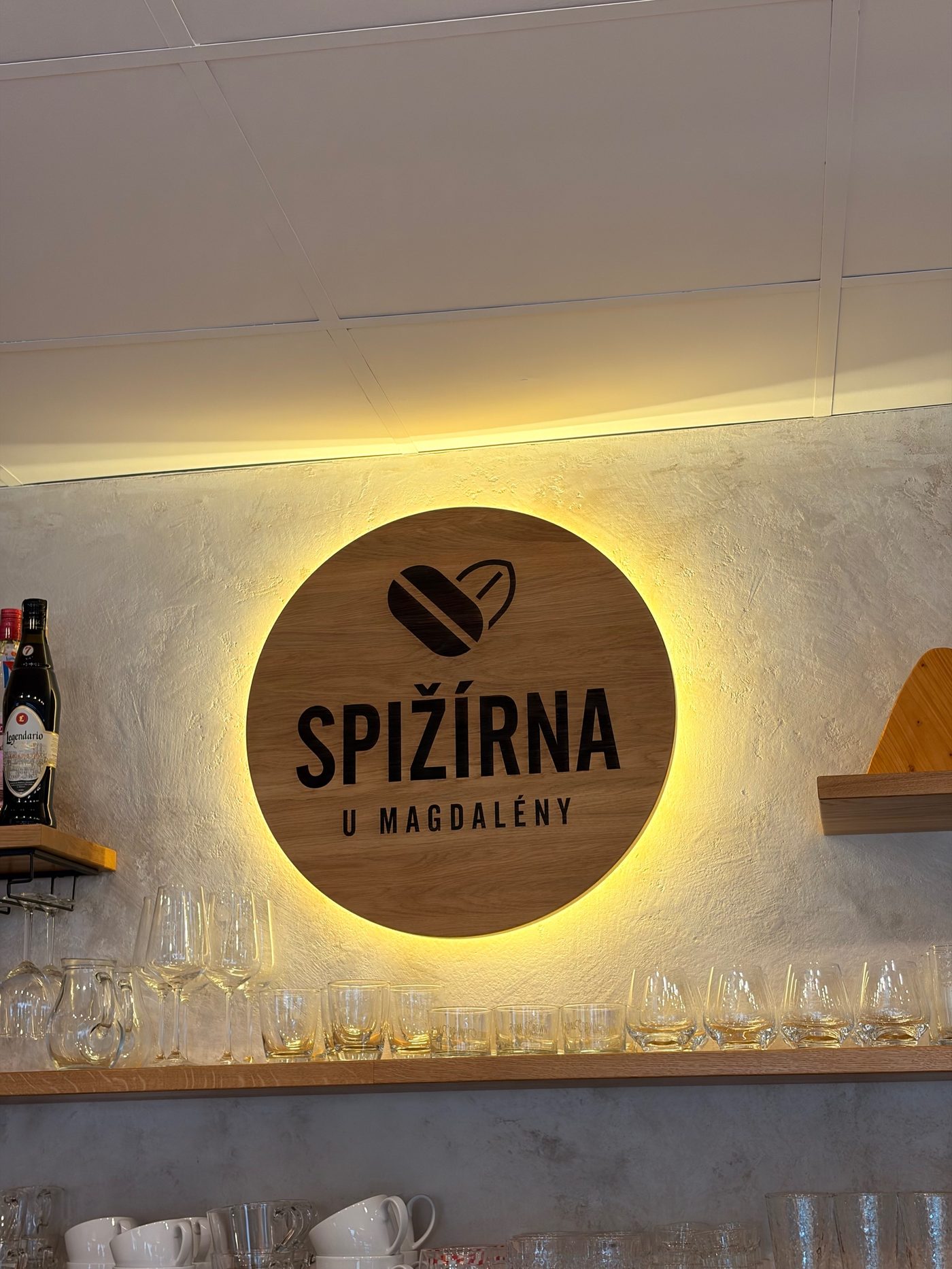 Prosvícená dřevěná cedule s logem a nápisem Spižírna u Magdalény
